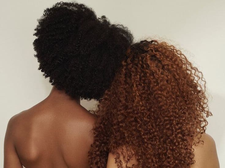 Two natural textures side by side — deep coils and auburn curls