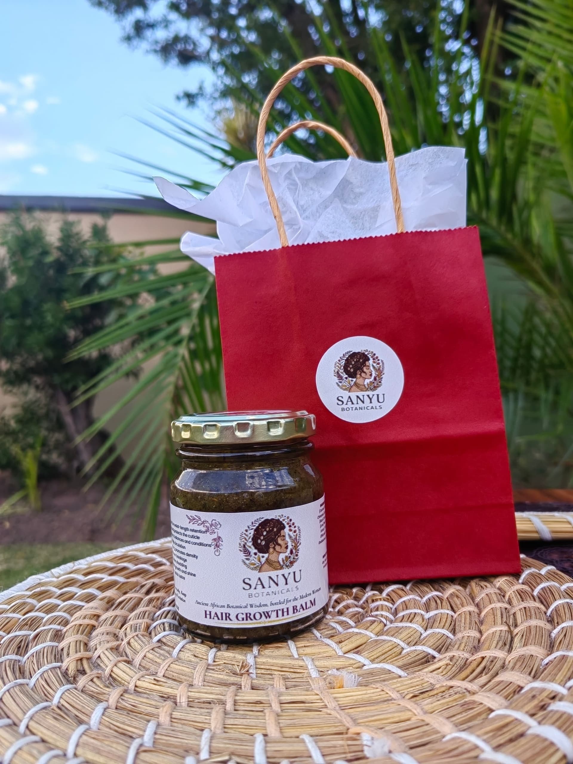 The maker's hands holding the Sanyu Hair Growth Balm